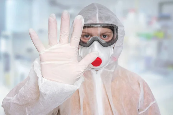 Scientist with FFP3 respirator mask is showing STOP gesture - SARS, MERS, CORONAVIRUS concept