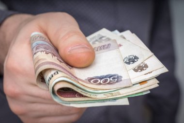 İnsanoğlunun elindeki Rus banknotlarına yakın çekim. İşadamı bazı hizmetler için para veriyor - finans kavramı.