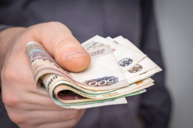 İnsanoğlunun elindeki Rus banknotlarına yakın çekim. İşadamı bazı hizmetler için para veriyor - finans kavramı.