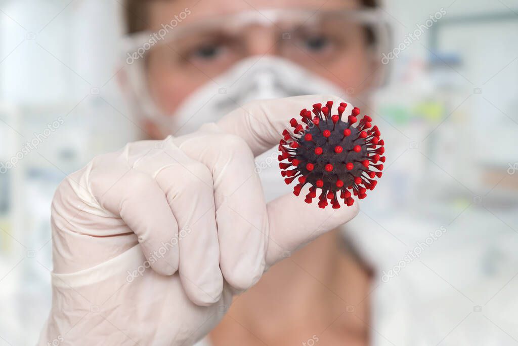 Woman scientist holding Corona Virus - COVID-19 in her fingers