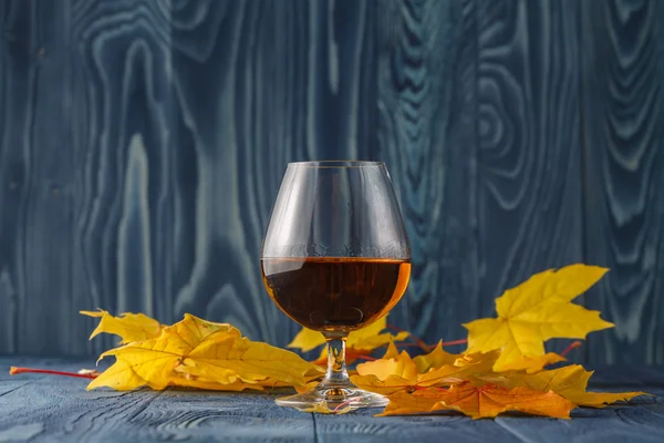 杯威士忌着树叶的桌子上 — 图库照片
