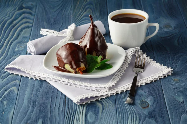 Peras en jarabe de caramelo con menta en un plato blanco con chocolate — Foto de Stock