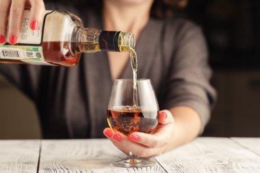 Alkolizm sorunu. Erkek koyu tonda masada Şarap kadehi almak