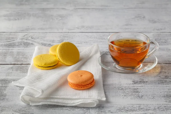 Copo quente de vidro de chá em uma mesa de madeira com macaroons — Fotografia de Stock