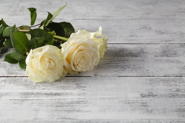 Rosas blancas sobre una mesa de madera — Foto de Stock