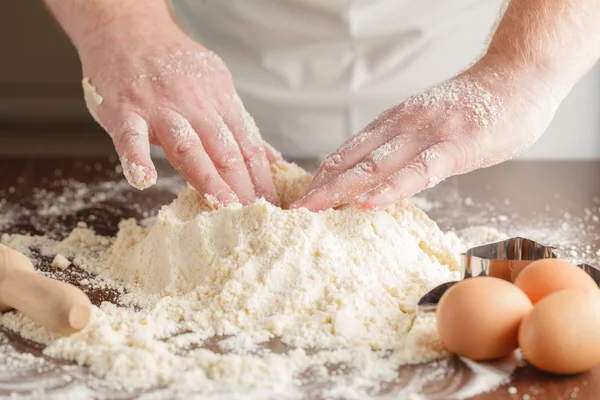 Mani di uomo impastando una pasta — Foto Stock