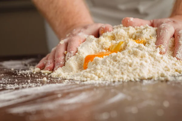 Eine Handvoll Mehl mit Ei auf einer rustikalen Küche. gegen den Rücken — Stockfoto