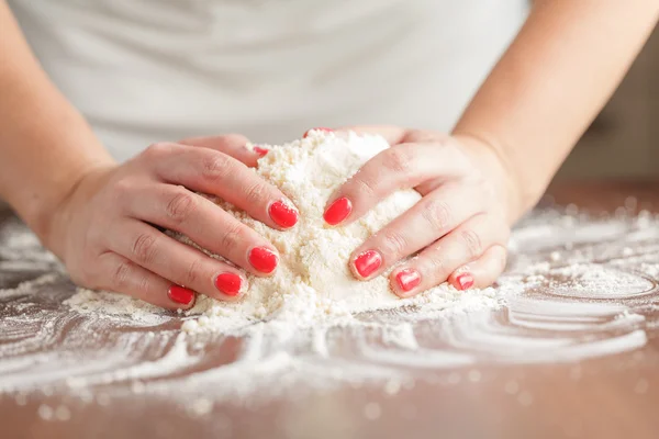 Dokonywanie surowe ciasto przez kobiece ręce na stole — Zdjęcie stockowe