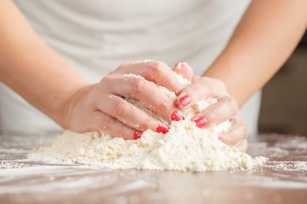 Рука женщины замесить тесто для дрожжевого пирога на деревянный стол, пре — стоковое фото