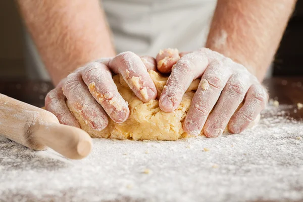 Fazendo massa por homens mãos em fundo de mesa de madeira — Fotografia de Stock