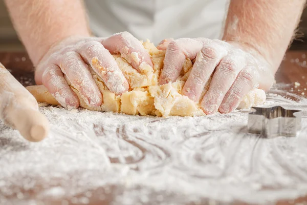 Dokonywanie ciasta przez męskie ręce na tle drewniany stół — Zdjęcie stockowe