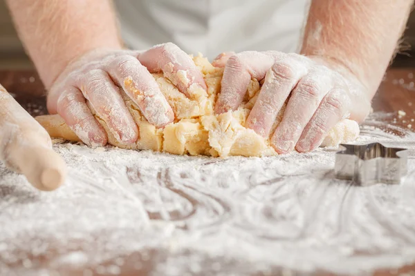 Fare pasta da uomo mani su sfondo tavolo di legno — Foto Stock