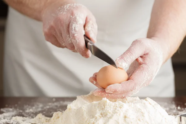 Koch bricht ein Ei — Stockfoto