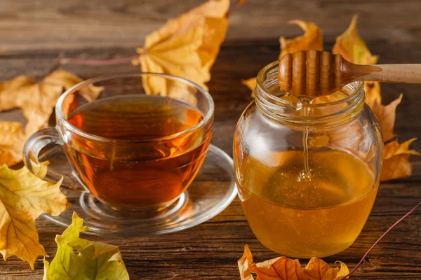 Rose hip čaj v transparentní cup a konvice na čaj s medem a na podzim — Stock fotografie