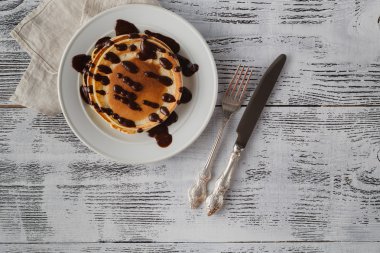 Yığın krep muz ve çikolata şurubu ile