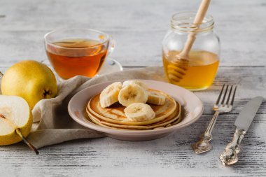 Bal şurubu ve bir beyaz tabak o tereyağı ile krep yığını