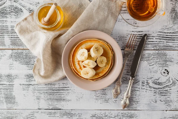 Stack of cottage cheese pancakes with honey and banana, selectiv — Stock Photo, Image