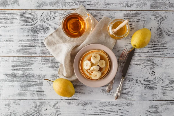 Pancakes with banana & walnut on wood background — Stock Photo, Image