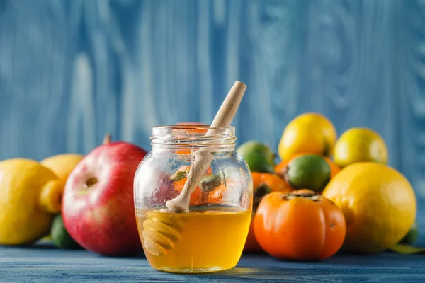 Apfel und Honig auf Holztisch vor blauem Hintergrund — Stockfoto