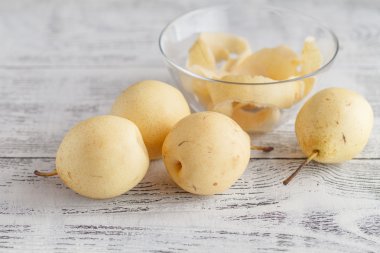 Lezzetli Çin sarı armut ve ahşap arka plan üzerinde fındık.