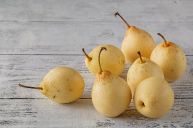 Köy ahşap bir masada taze taze organik armutlar.