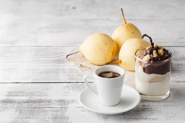 Pera con salsa al cioccolato su un tavolo bianco — Foto Stock