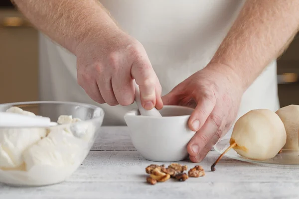 Homem preparando ingredientes para cozinhar molho usando argamassa e pes — Fotografia de Stock