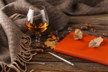 Fincan çay ile eski kitap, ahşap masa üzerinde sonbahar yaprakları