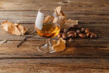 Konyak cam masanın üzerine kurutulmuş sonbahar yaprakları ile