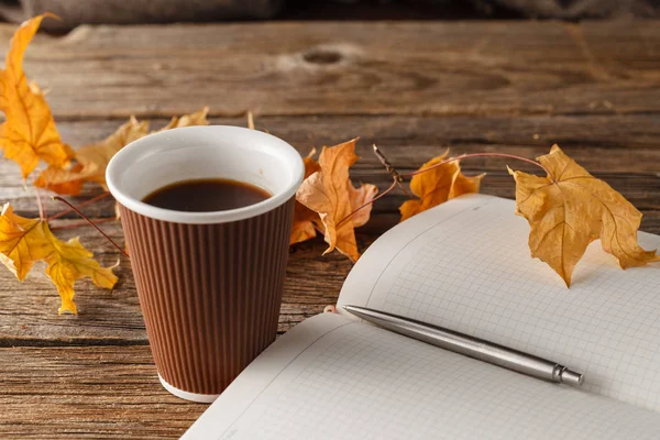 Fincan çay ile eski kitap, ahşap masa üzerinde sonbahar yaprakları — Stok fotoğraf