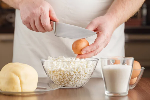 Повар разбивает яйцо в миску — стоковое фото