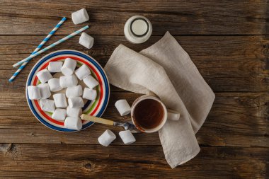Tahta masanın üstünde lokum olan bir fincan sıcak kakao.
