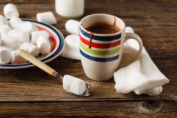 Eine unordentliche Tasse mit heißer Schokolade, Schlagsahne, Marshmallows und — Stockfoto