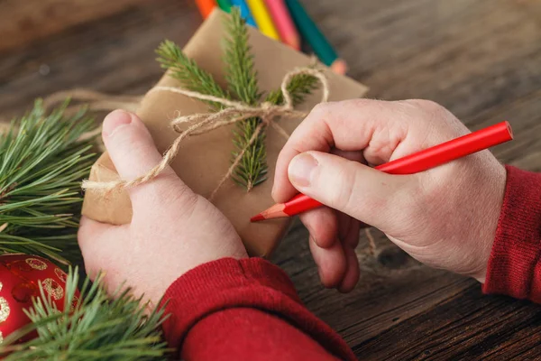 Erkek el Noel hediyesi koyu ahşap sekmesini kağıda sarılmış — Stok fotoğraf