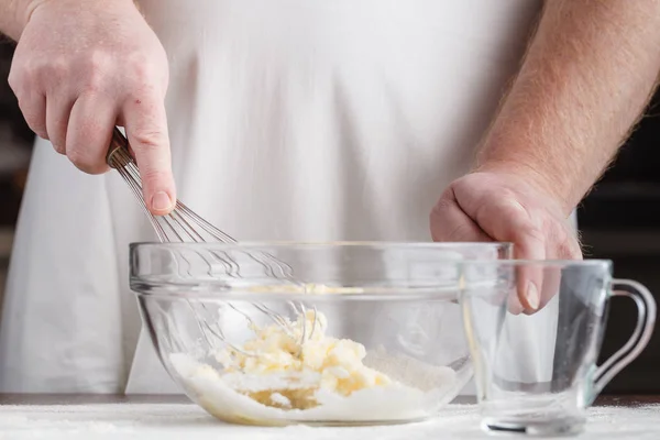 Professionella manliga bagare matlagning deg med ägg, smör och mjölk — Stockfoto