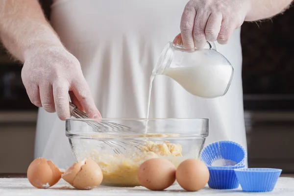 Homem assar e misturar farinha com leite e ingredientes muffin — Fotografia de Stock