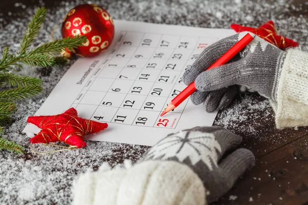 Gils in glowes mark calendar with christmas date — Stock Photo, Image