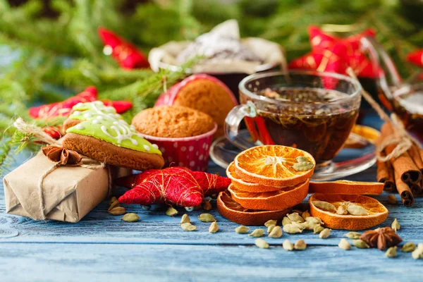 bir fincan sıcak çay ve bir çaydanlık. Tarçın, anason, kurabiye ve Ladin