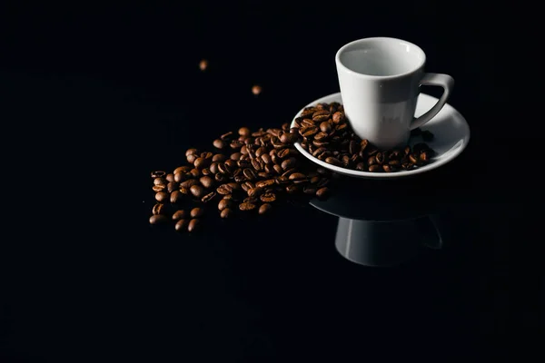 Taza blanca volcada con granos de café — Foto de Stock