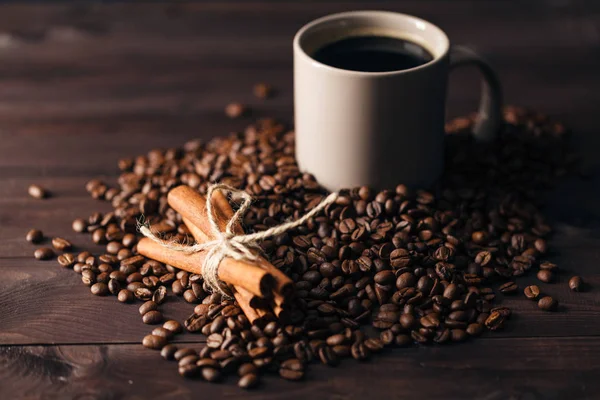 Кавові зерна і чашка кави на столі на коричневому фоні — стокове фото