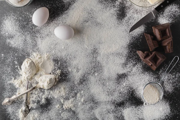 Baka kaka ingredienser. Skål, mjöl, ägg, eggbeater på svart c — Stockfoto