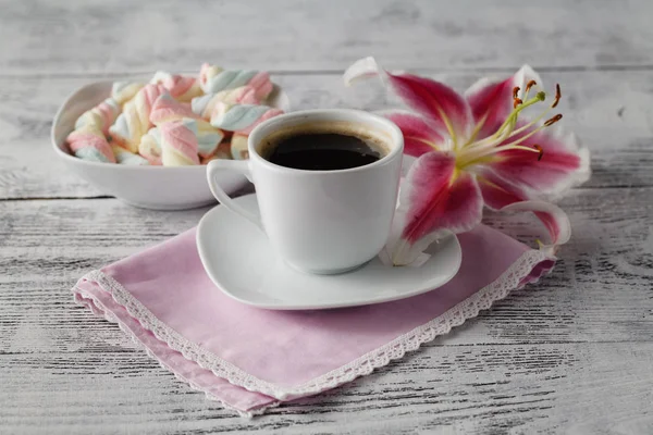 Sweets with coffee and lily flower on table — Stock Photo, Image