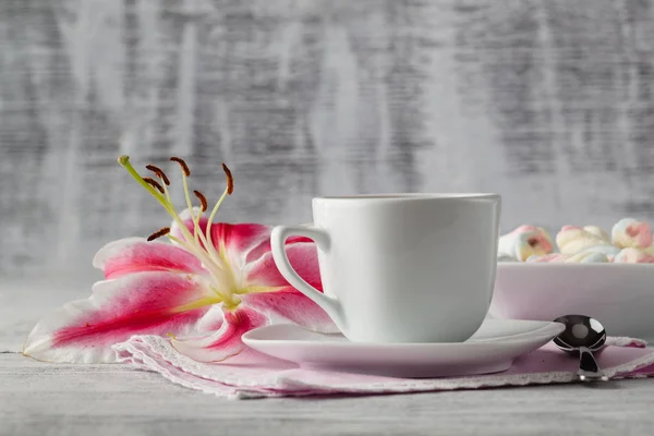 Dulces con café y flor de lirio en la mesa — Foto de Stock