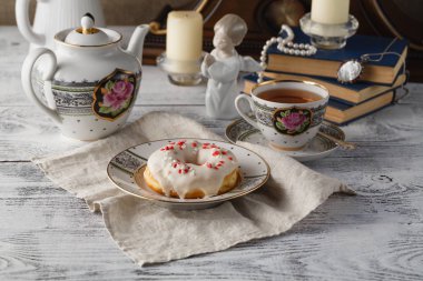 Çörek ve çay ile Servis Kahvaltı. Tablo üzerinde eski kitaplar