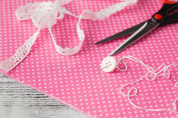 İğne ve pembe puantiyeli bez düğmesini