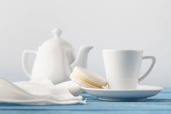 Чашка белого фарфора с чаем и один макарон — стоковое фото