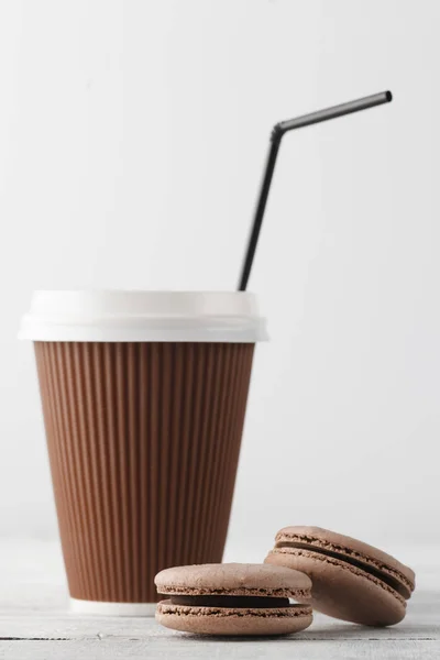 Caffè da asporto e due amaretti sul tavolo bianco — Foto Stock