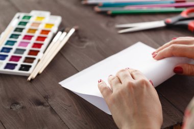 Kadın bir parça kağıt origami için eğilir