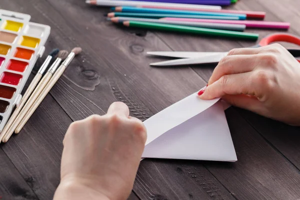 Mujer hacer origami, doblar hoja de papel para hacer figura — Foto de Stock