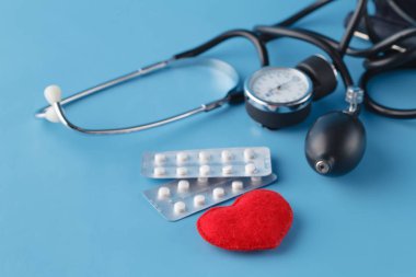 Kalp sağlık kavramı, thonometer ve oyuncak kalp mavi backg